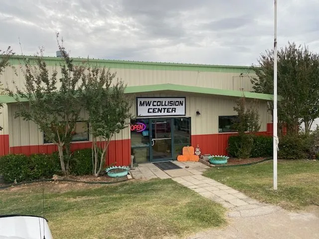 Front of the MW Collision Center building with its sign over the door and an open sign in the window